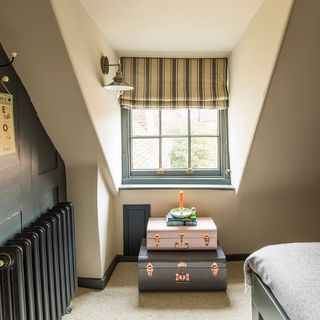 attic bedroom with trunks and radiator