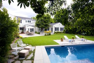 white house with garden and pool by Kate Anne Designs