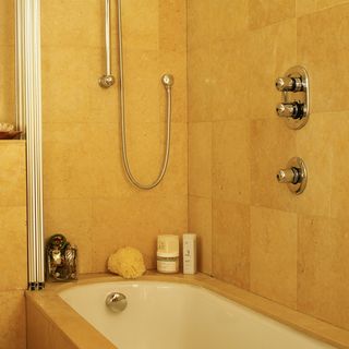 bathroom with stone tiles and bathtub