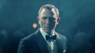 Daniel Craig stands confused in a cloud of mist in No Time To Die.