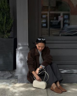 @dawn.tan wearing brown loafers with grey trousers and brown suede jacket