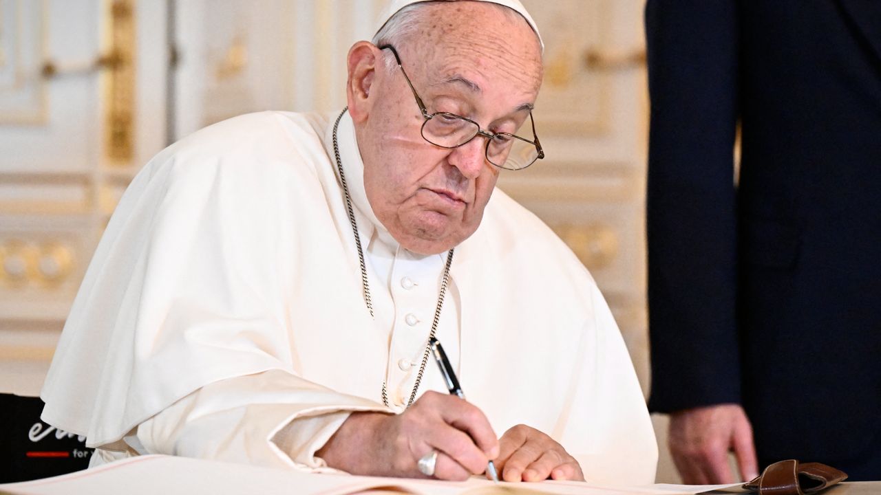 Pope Francis signs a book in Luxembourg