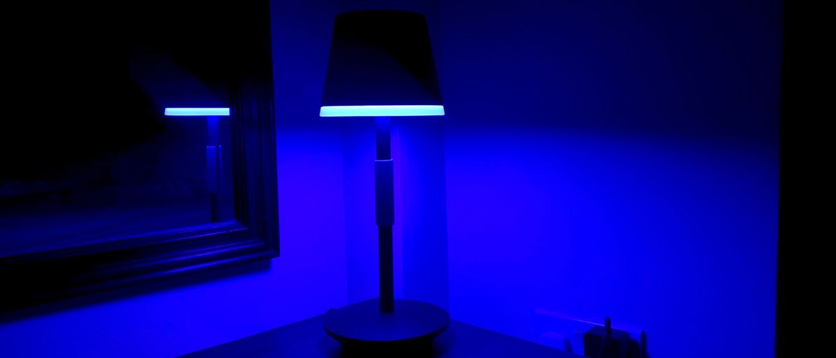 Philips Hue Go portable table lamp on a bedside table