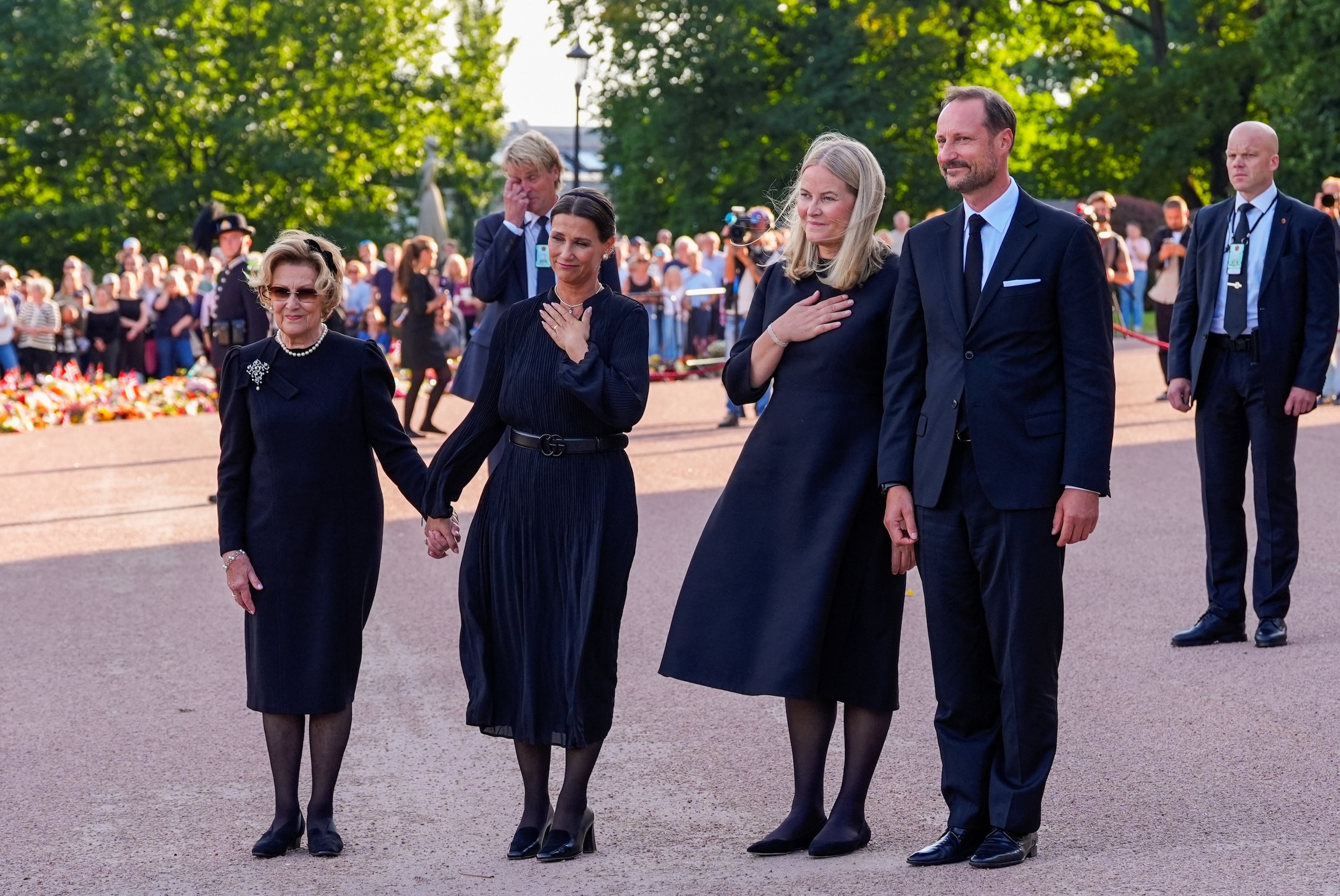 Queen Sonja, Princess Martha Louise, Queen Mette-Marit and King Haakon wearing black standing in a row