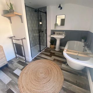 bathroom with roll-top bath, wood look flooring, a jute rug and shower with Art Deco tiles