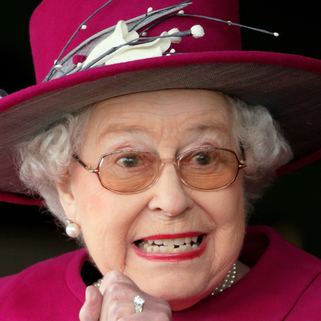 Queen Elizabeth gritting her teeth in a pink hat and coat