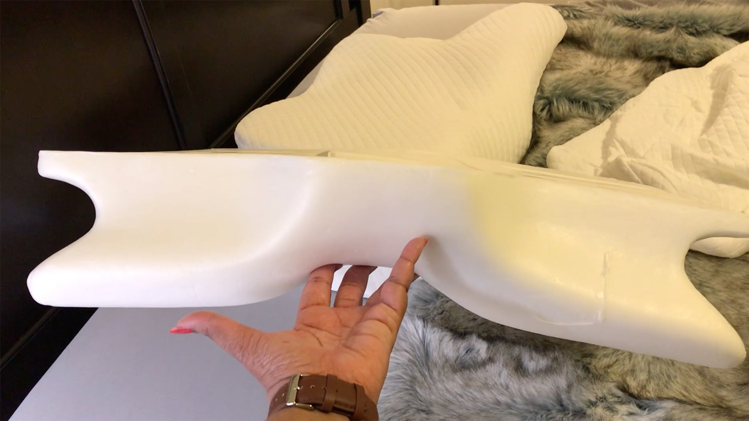 a hand holding a Zamat Butterfly Shaped Cervical Memory Foam Pillow's memory foam filling