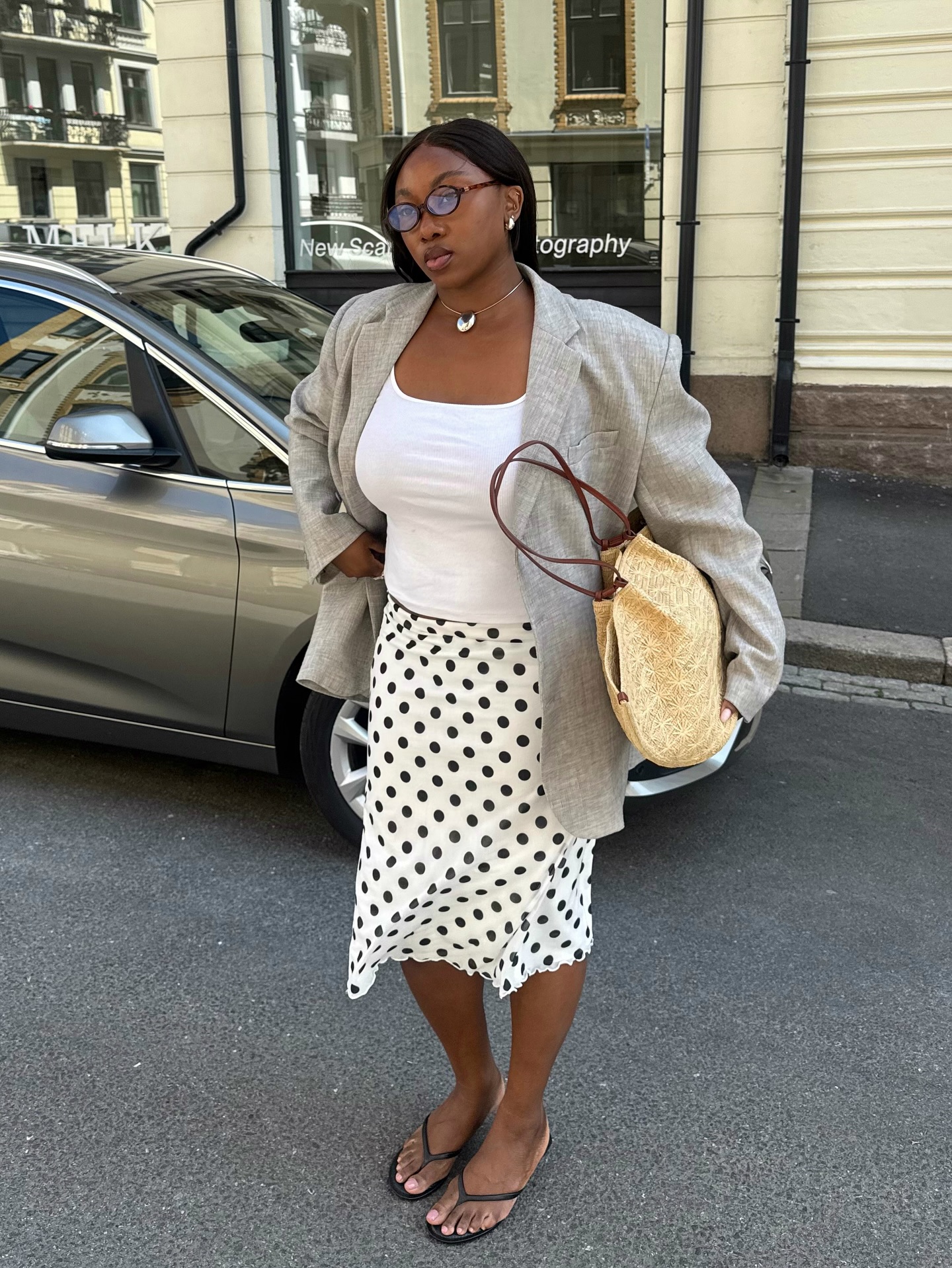 How to style a tank top: @nnennaechem wears a tank top with a blazer and polka dot skirt