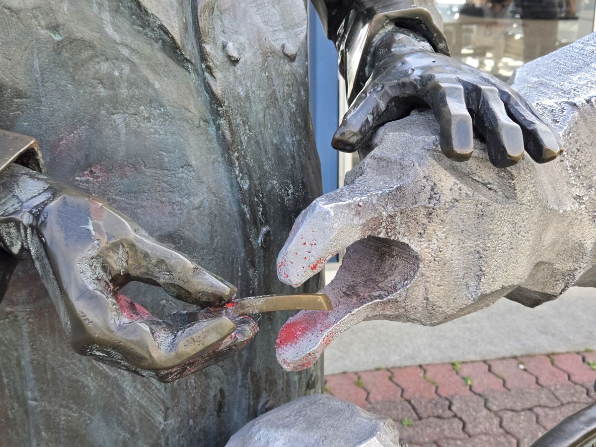 A statue of a man feeding a seagull