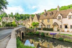 A picturesque view of cottages with Cotswold stone walls in Castle Combe, Cotswolds, England.