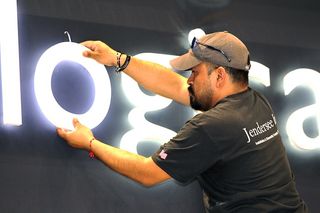 Carpenter Jose Sotelo assembles the signage on TV-app maker Metrological’s booth on the INTX show floor.