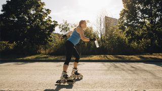 Female athlete roller skating on street during a sunny day