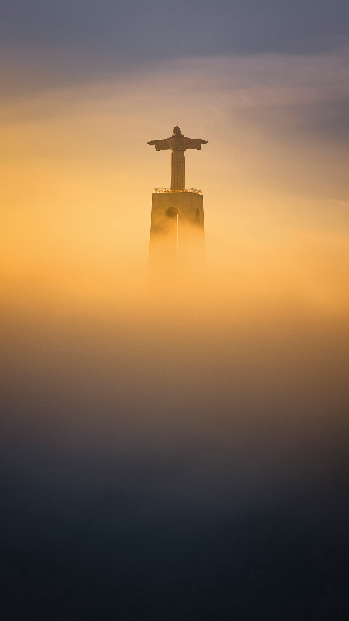 A stature positioned in the middle of the composition that half disappears in the fog/mist and is mystically enveloped, fog/mist appears yellowish and very color intensive
