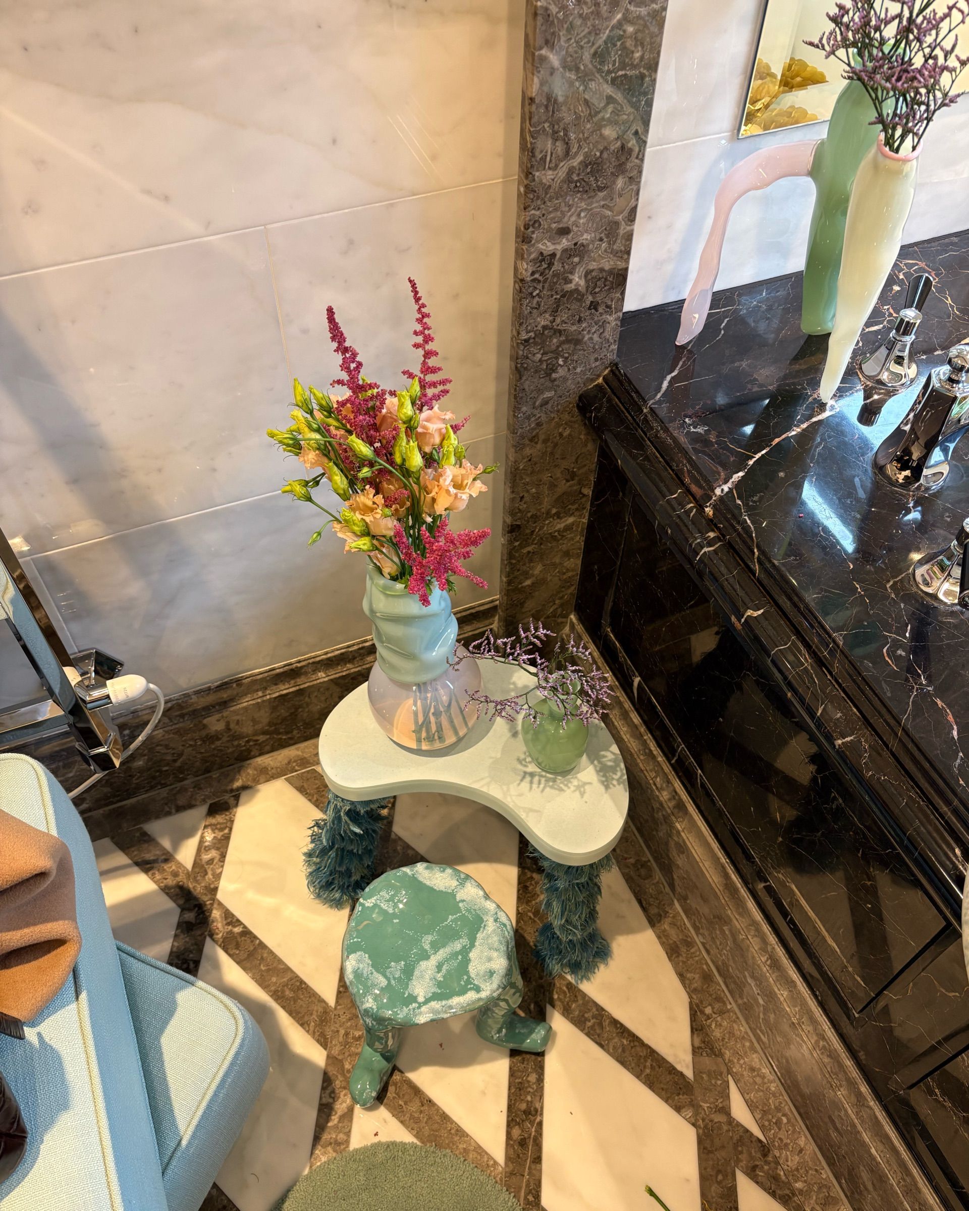 A lavish hotel suite filled with whimsical, sea green and blue-tinted homeware, curtains, and accessories.