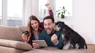 Happy couple shopping online with their dog for the best Amazon Prime Day pet deals