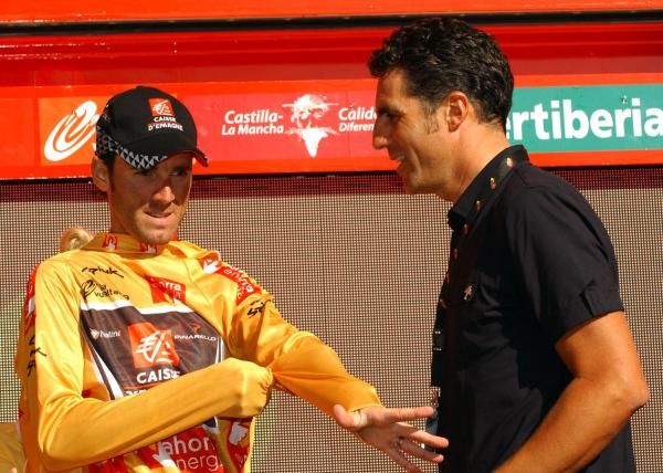 Alejandro Valverde gets his golden jersey from Miguel Indurain.