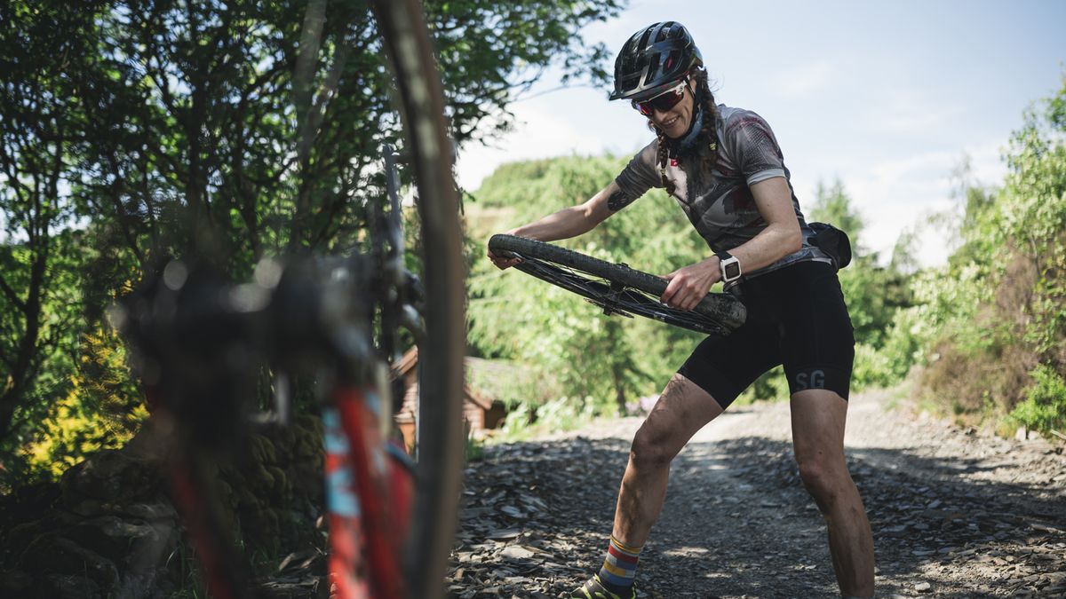 A cyclist repairs a puncture at the side of the road