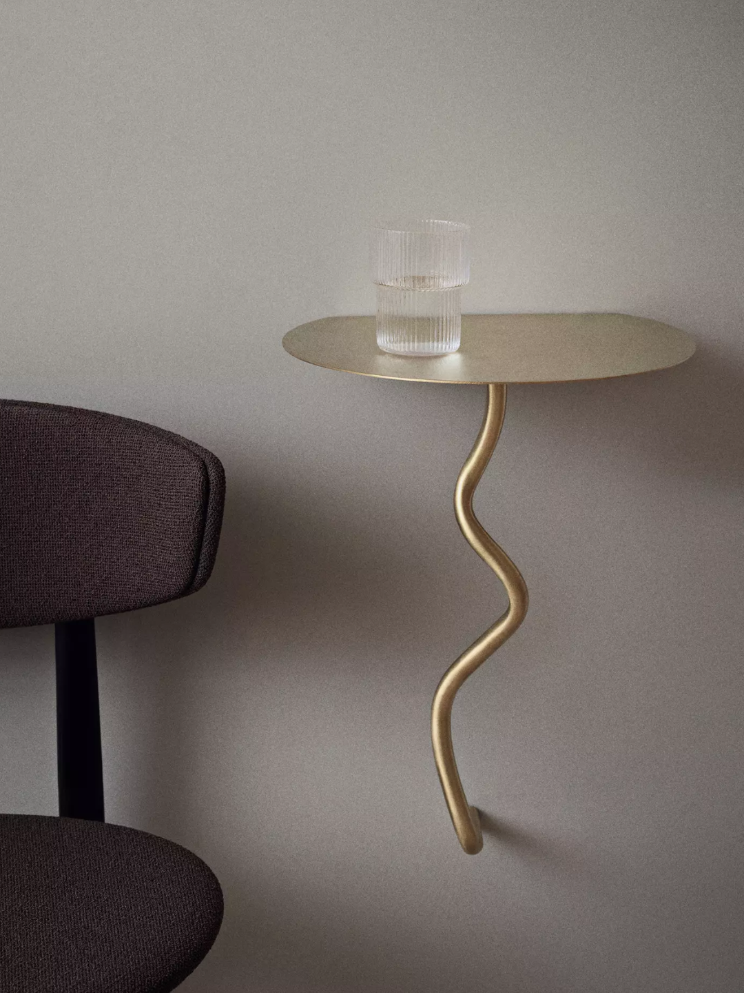 A gold curved wall-mounted side table
