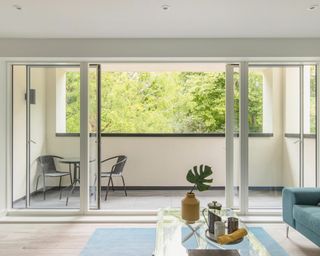 Stylish show home living room of a contemporary apartment with open sliding doors onto a balcony