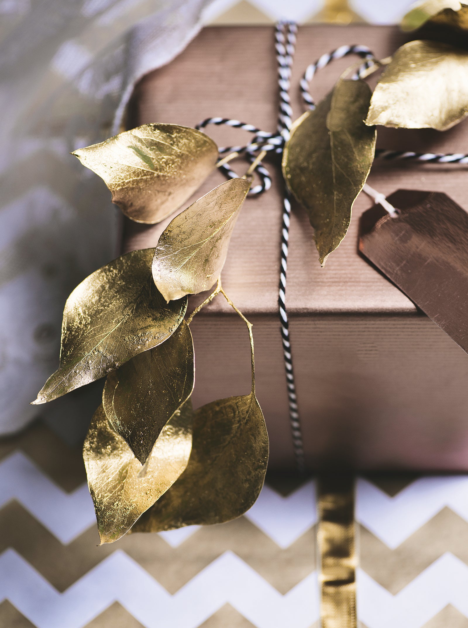 Present wrapped with copper wrapping paper, gold sprayed leaves