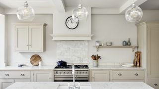 Pale gray painted kitchen with range cooker and kitchen island to show neutral paint color ideas for a kitchen