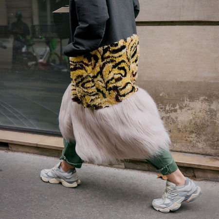 Model wears sneakers and textured dress. 
