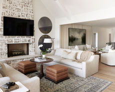 a neutral living room with brown leather stools