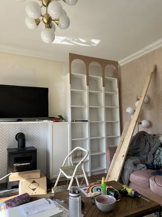 A living room with a built in bookcase in the process of being build