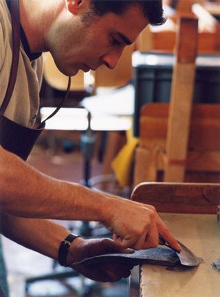 A man carving the saddle from the leather