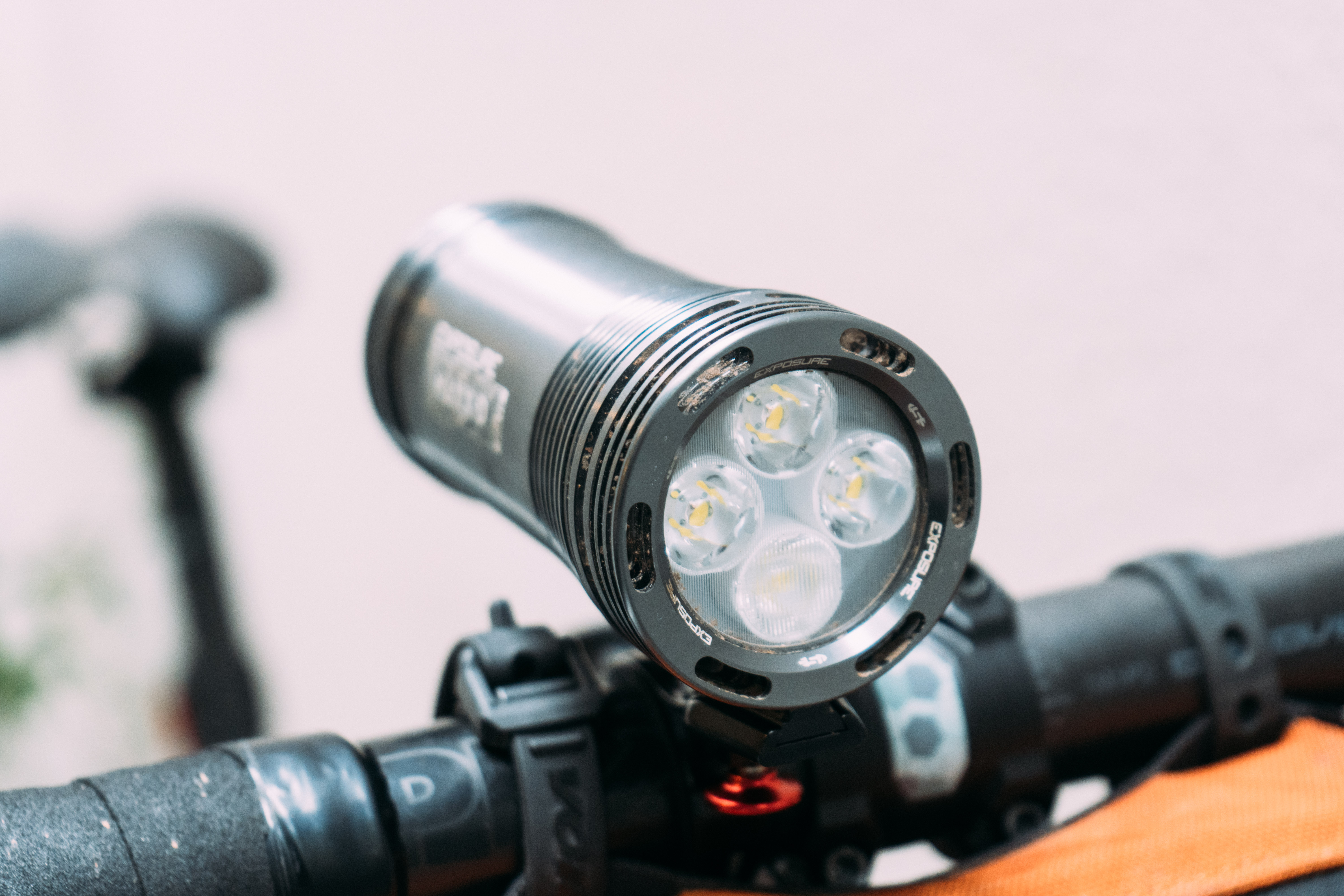 A close up of the front of a large silver bike light, showing 4 LED bulbs