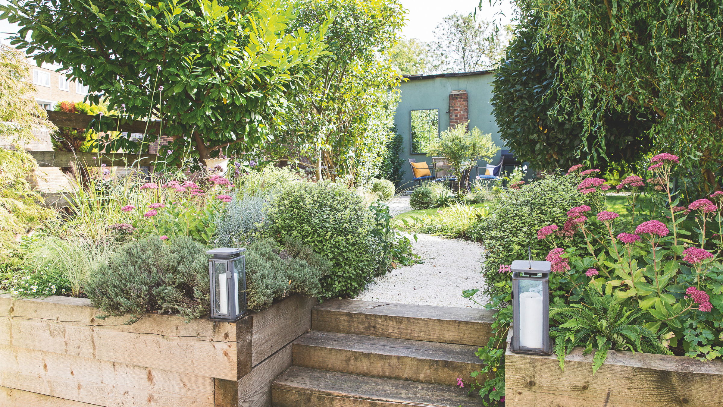 Steps up between the raised beds to the gravel path leading through the garden to the seating area at the end of the garden.