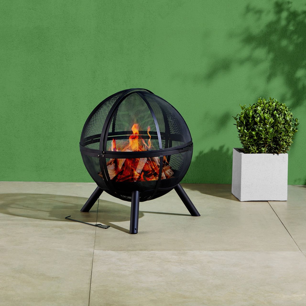 Tesco Outdoor Living fire pit against a green wall