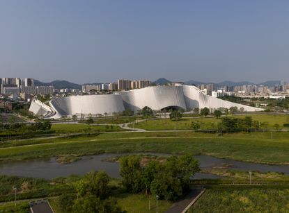 undulating forms of the Shenzhen Natural History Museum by 3XN, B+H Architects and Zhubo Design in a green park