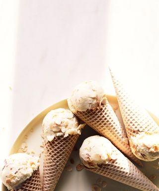 A close up shot of ice cream in cones on a plate