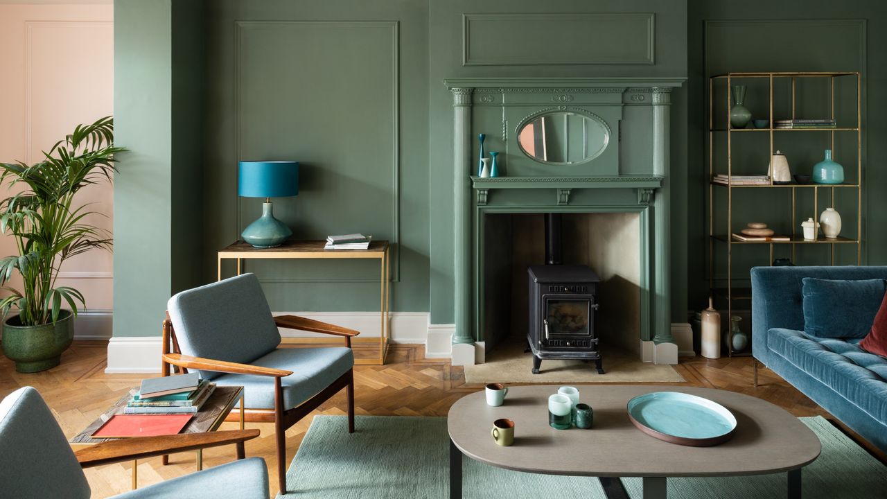 A green living room painted in Farrow &amp; Ball&#039;s Green Smoke shade with mid-century modern style furniture