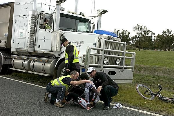 Curtis Gunn is attended to by team manager Henk Vogels (right) and medico Bobby Hall after crashing out of the tour.