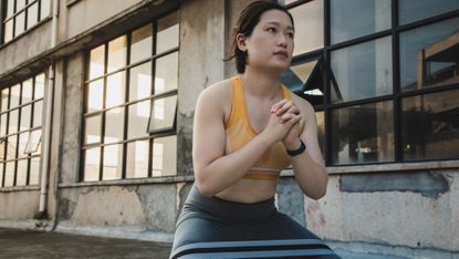 Woman doing a squat with resistance band above knees