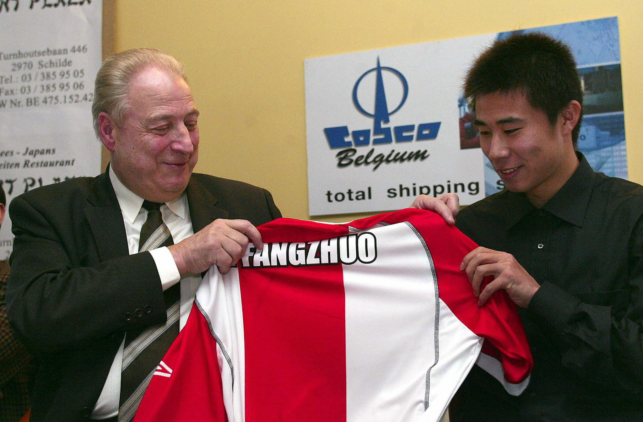 Dong Fangzhou holding up a Royal Antwerp shirt after joining on loan from Manchester United