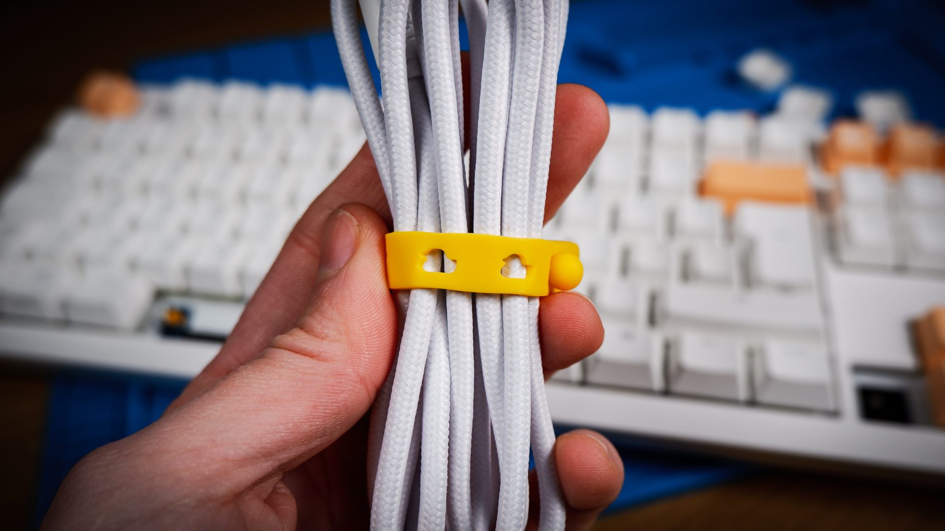 The Ducky One X induction gaming keyboard on a blue mat on a desk, with keycaps removed.