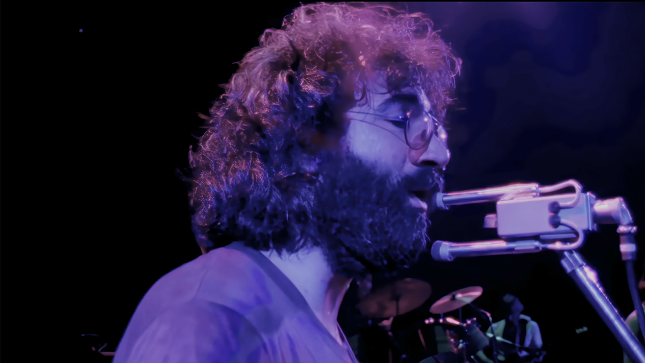 Jerry Garcia singing into a microphone in The Grateful Dead Movie