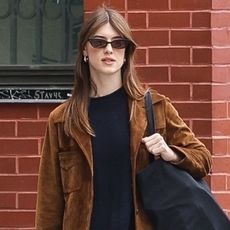 Daisy Edgar-Jones wearing a brown suede blazer, black sweater, vintage jeans, socks, and black loafers in SoHo.