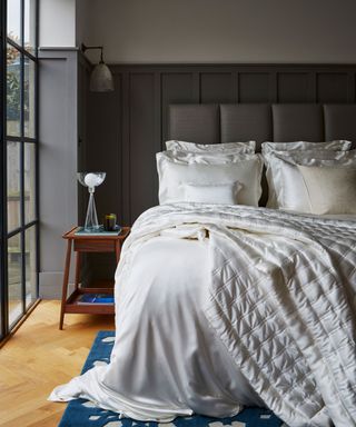 gray bedroom with ivory silk bedding on bed