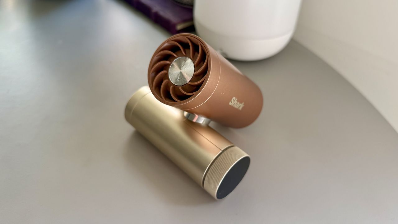 The shark chillpill portable fan in the shade latte pictured on a grey table