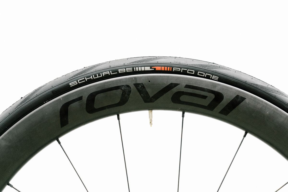 An aero road wheel stands against a white wall