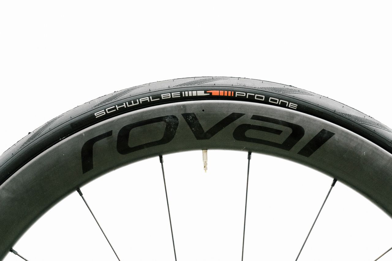 An aero road wheel stands against a white wall