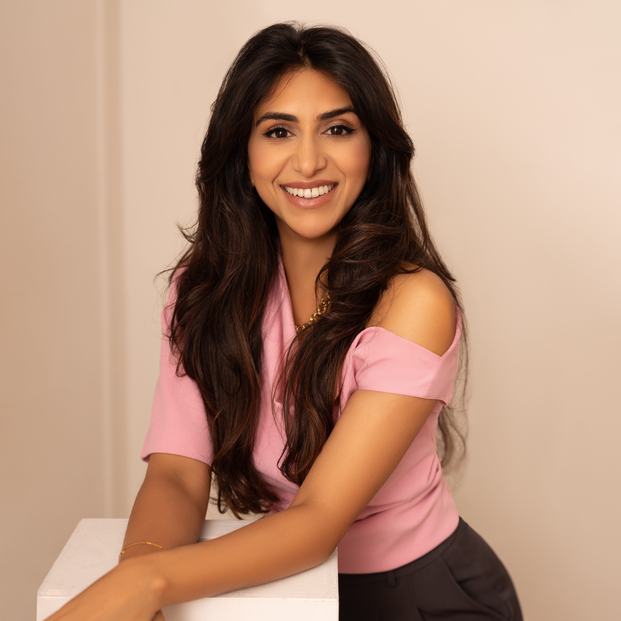 a brown woman with long dark hair in a pink top