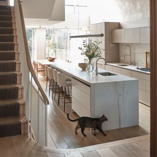 Large neutral kitchen diner, with island, wood floors and large glazing to the garden