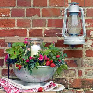 Brick wall with lantern and strawberries