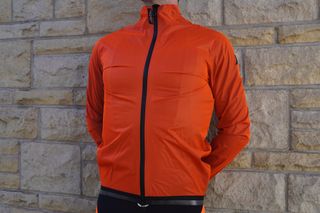 Image shows a cyclist wearing the Assos Equipe RS Rain Jacket Targa.