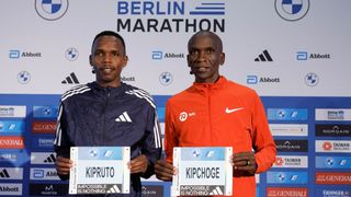 Kenya's world record holder Eliud Kipchoge (R) and Kenya's Amos Kipruto pose with their bib at a press conference on September 22, 2023 in Berlin